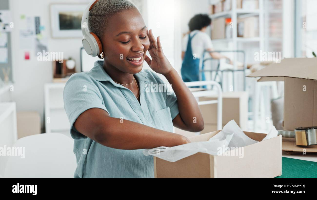 Schwarze Frau, Musik-Kopfhörer und Tanz im Büro, E-Commerce-Logistikunternehmen oder kreatives E-Commerce-Startup. Lächeln, glücklich und aufgeregt Stockfoto