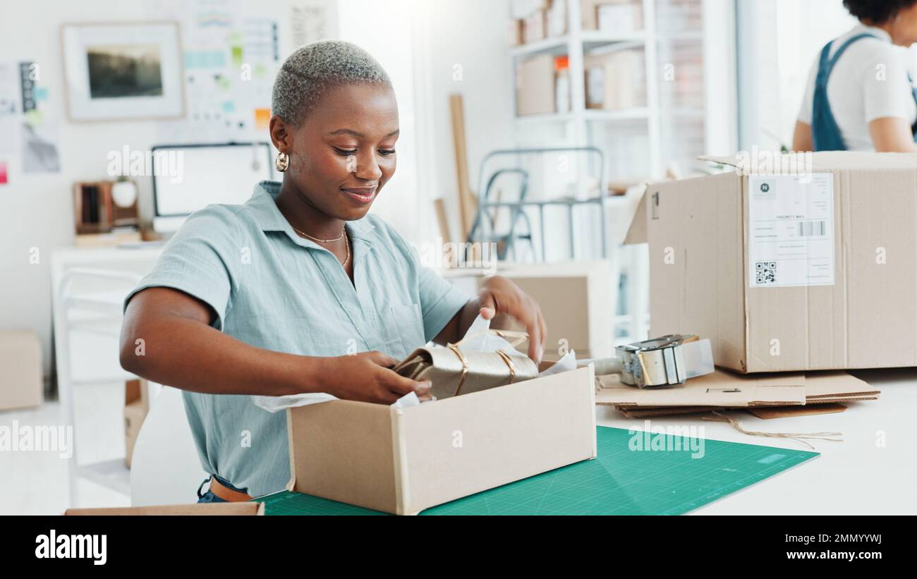 Startup, Shop und Unternehmer, die eine Schachtel für eine Bestellung von Produkten für den Versand oder die Lieferung verpacken. Schwarzer Geschäftseigentümer, der ein Einzelhandelspaket für vorbereitet Stockfoto