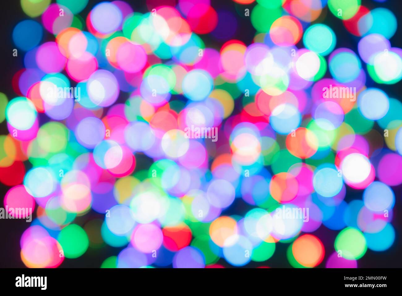 Bunte, verschwommene Lichtkreise auf schwarzem Hintergrund. Farbenfrohe Bokeh-Kulisse Stockfoto
