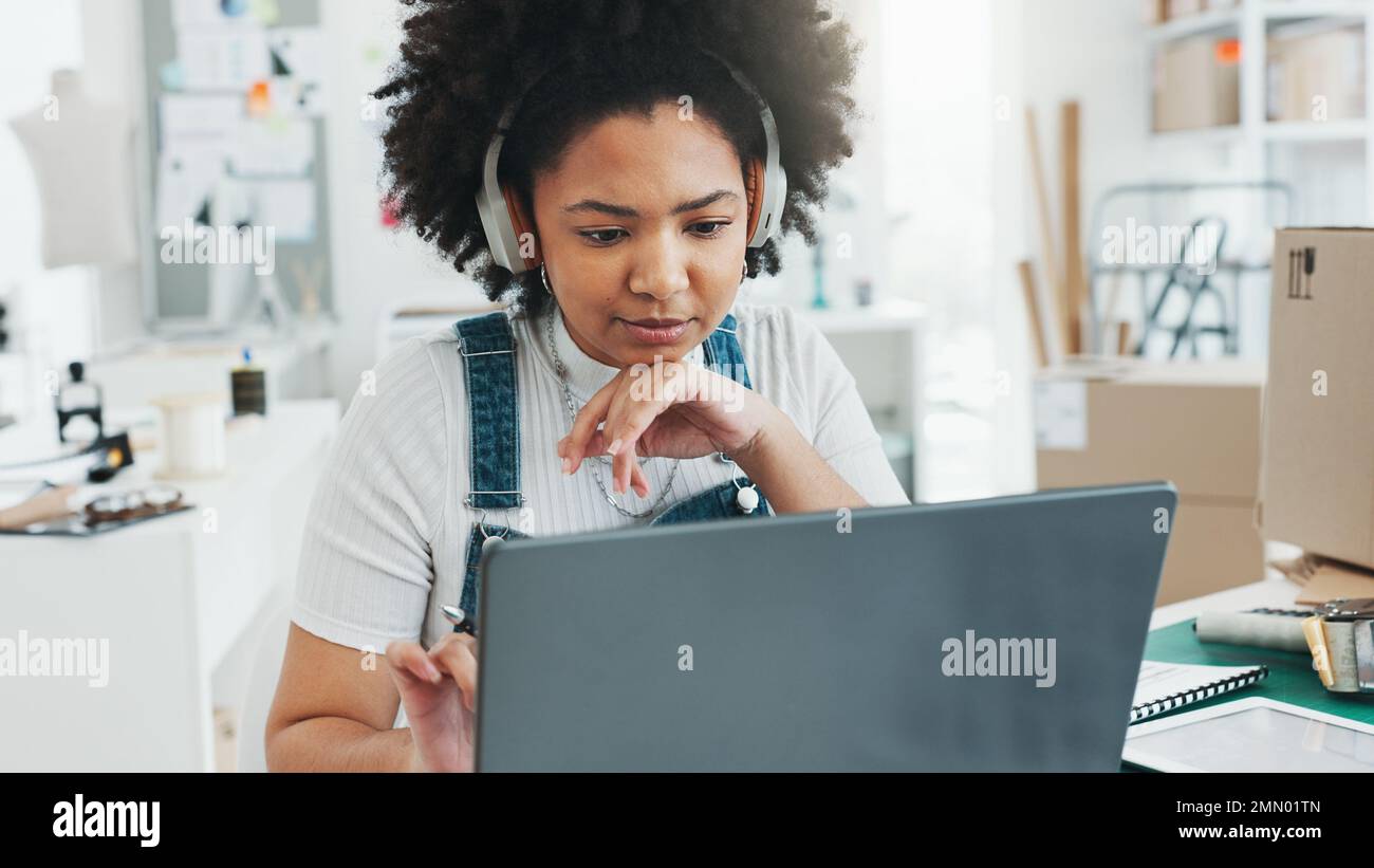 Schwarze Frau, Laptop und Notebook zum Lernen im Büro, zu Hause oder im Studio zum Design. Frau, Musik und Hören über Kopfhörer, während Sie online mit lernen Stockfoto