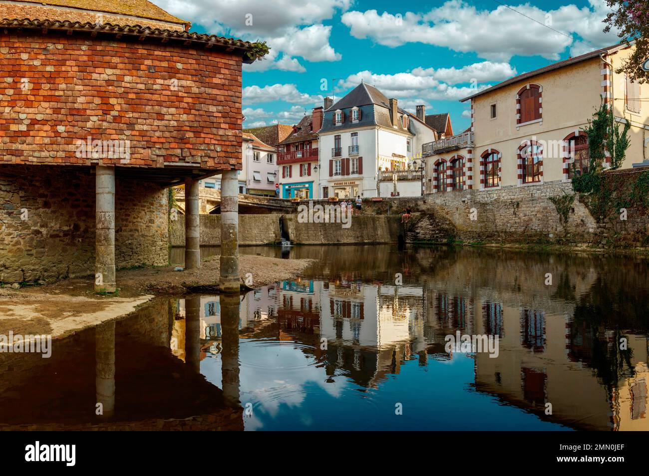 Frankreich, Pyrenäen Atlantiques, Bearn, Salies de Bearn, Fluss, der das historische Stadtzentrum der Marktstadt Salies bei Sonnenuntergang unter bewölktem Himmel kreuzt Stockfoto