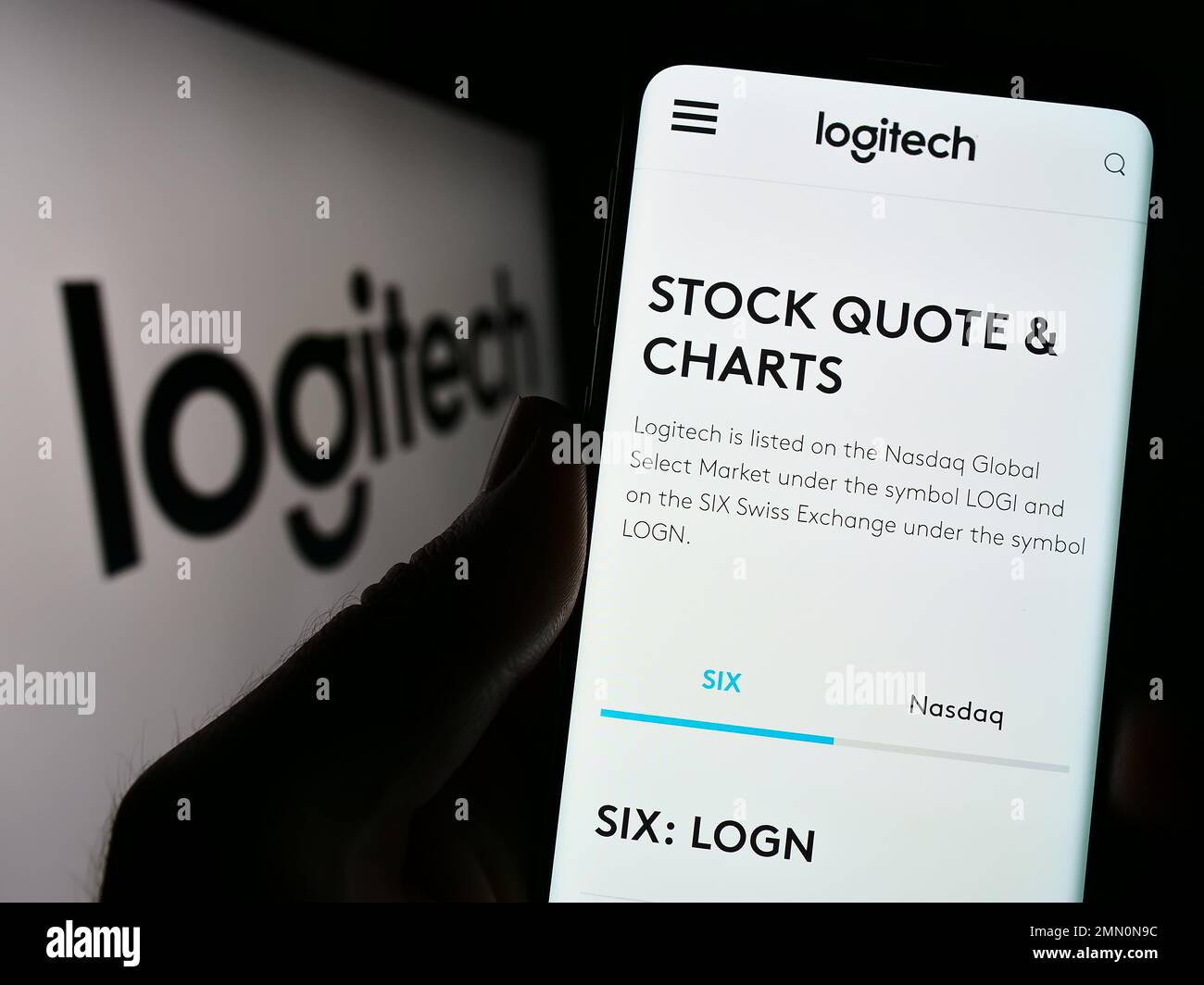 Person, die ein Mobiltelefon hält, mit Webseite des Schweizer Unternehmens Logitech International S.A. auf dem Bildschirm vor dem Logo. Konzentrieren Sie sich auf die Mitte des Telefondisplays. Stockfoto