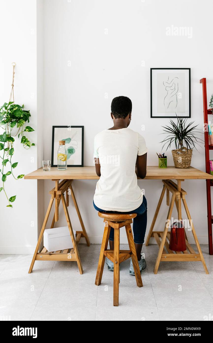 Kreative junge afrikanische Frau, die im Studio zu Hause am Laptop arbeitet Stockfoto