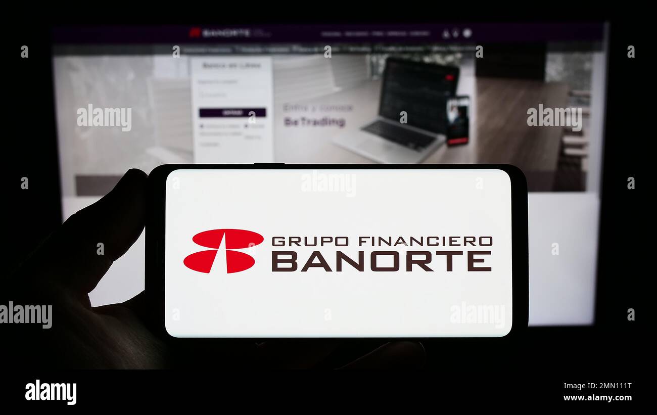 Person, die ein Smartphone mit dem Logo des mexikanischen Bankunternehmens Grupo Financiero Banorte auf dem Bildschirm vor der Website hält. Konzentrieren Sie sich auf das Display des Telefons. Stockfoto