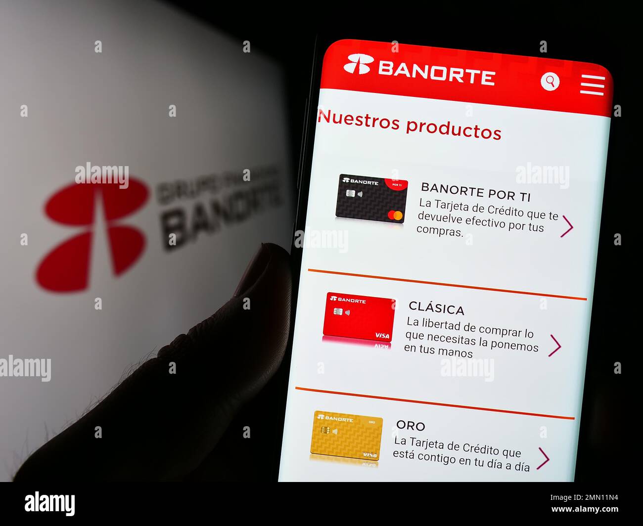 Person mit Smartphone und Webseite des mexikanischen Bankunternehmens Grupo Financiero Banorte auf dem Bildschirm mit Logo. Konzentrieren Sie sich auf die Mitte des Telefondisplays. Stockfoto