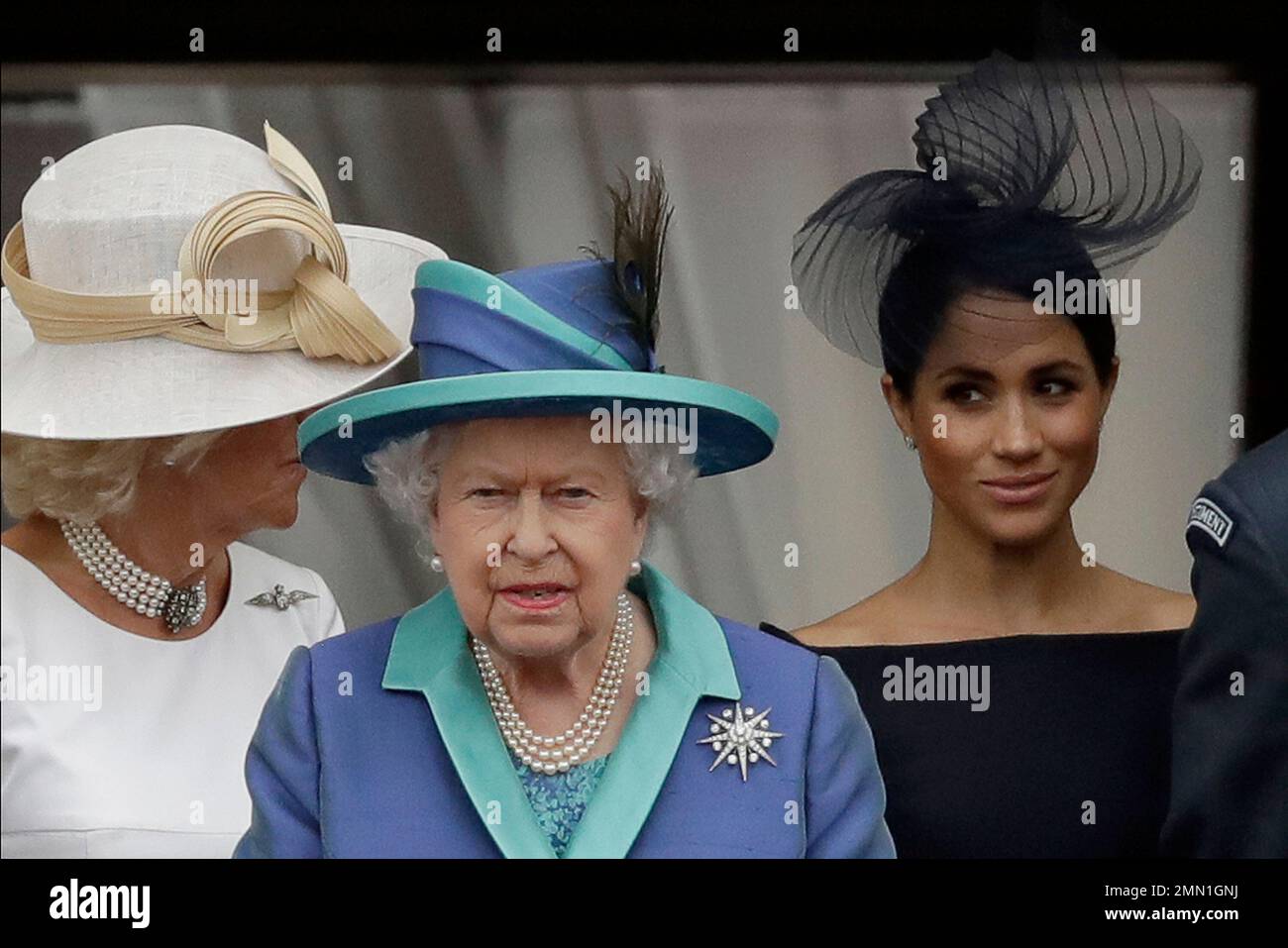 CORRECTING TITLE OF CAMILLA TO DUCHESS OF CORNWALL - Britain's Queen Elizabeth II, Camilla the Duchess of Cornwall, left, and Meghan the Duchess of Sussex walk out onto the balcony to watch a flypast of Royal Air Force aircraft pass over Buckingham Palace in London, Tuesday, July 10, 2018. Various events were held Tuesday to mark the centenary of the RAF. (AP Photo/Matt Dunham) Stockfoto
