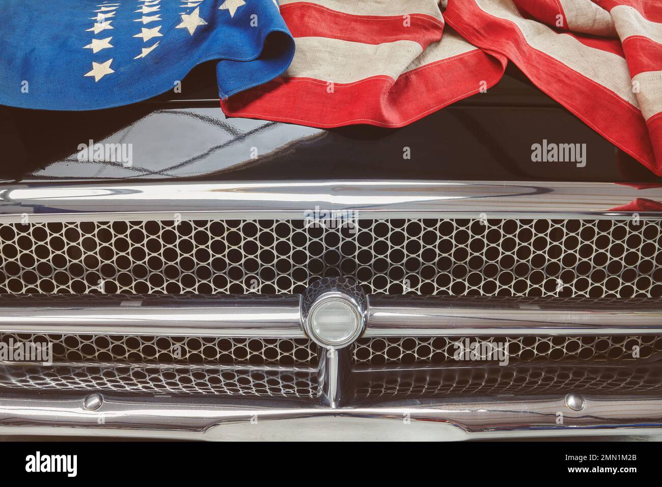 Klassisches schwarzes Auto mit einer alten amerikanischen Flagge auf der Motorhaube Stockfoto