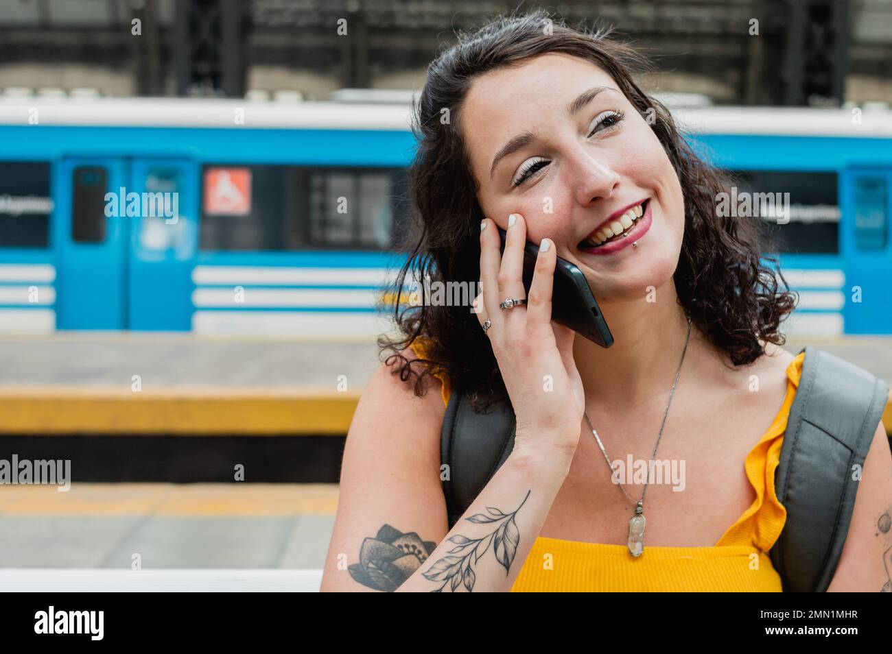 Wunderschöne junge argentinische Frau lächelte und sprach am Telefon und sagte Auf Wiedersehen zu ihrer mutter, wartete darauf, dass der Zug an Bord ging und machte eine Fahrt durch Stockfoto