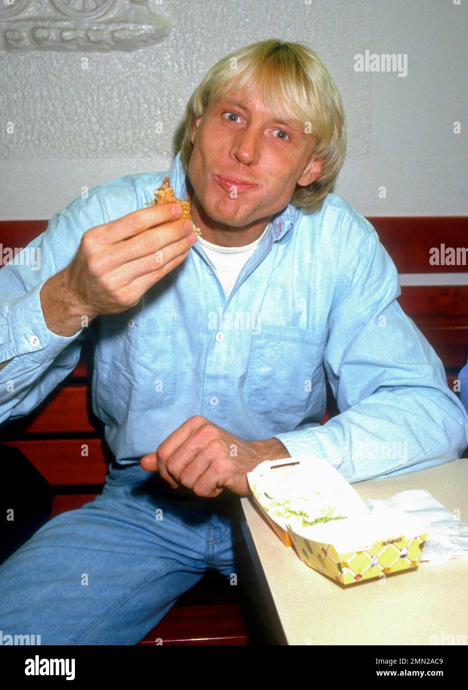 CARLO TRÄNHARDT deutscher Hochspringer hat einen Hamburger als Snack Stockfoto