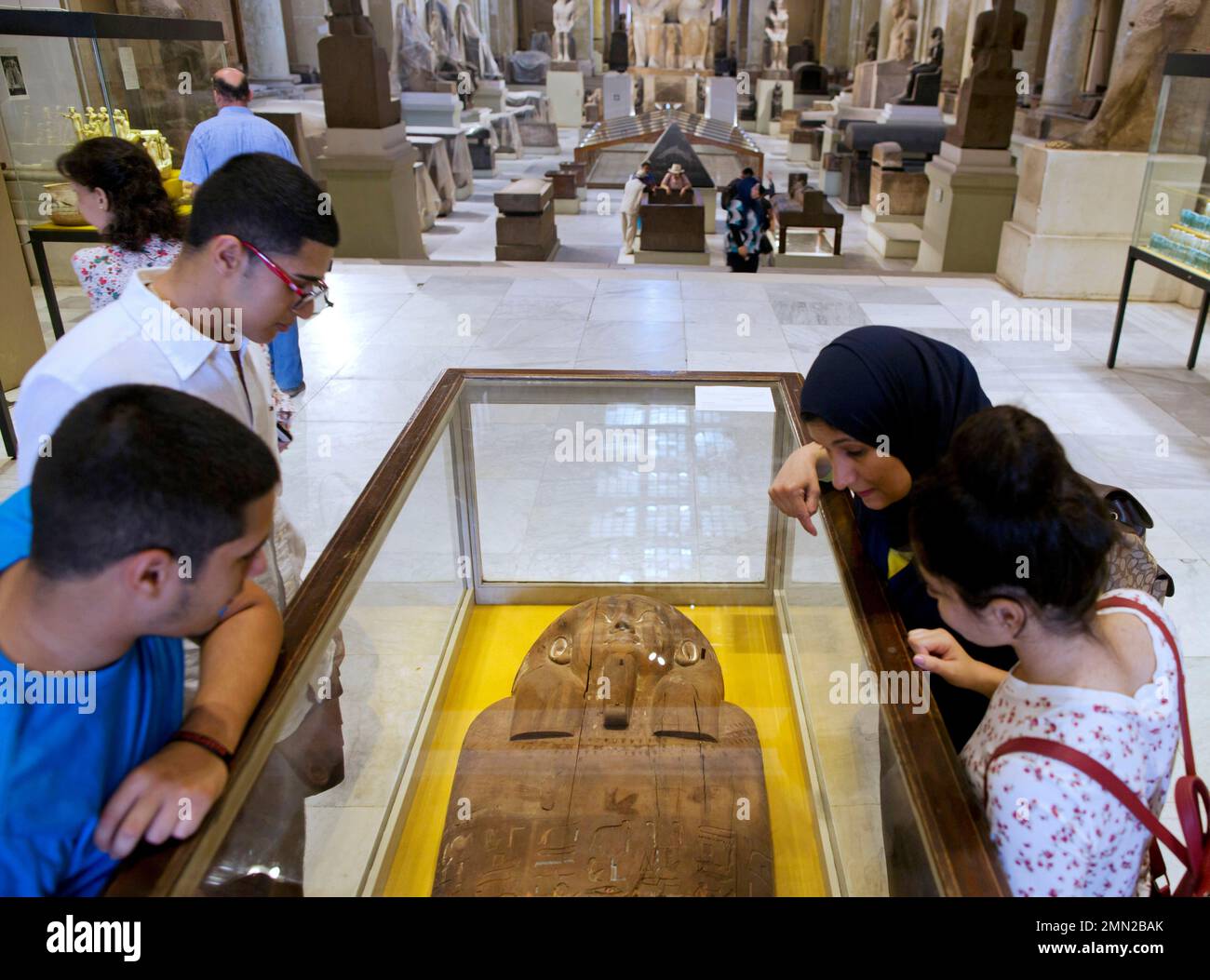 Visitors look at the lid of a wooden coffin that was confiscated by the