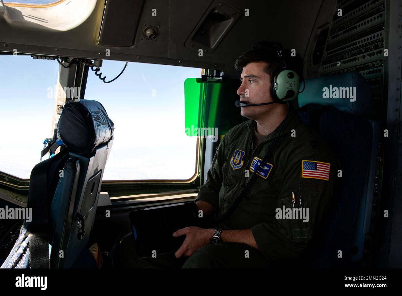 Kapitän Neil Brown, 301. Luftschubstaffel C-17 Globemaster III Pilot, schaut aus dem Fenster eines C-17 Globemaster III am 24. September 2022. Der 349. Luftwaffenflügel führte eine dreitägige Mission durch, um humanitäre Fracht nach Haiti zu transportieren. Über das Denton-Programm wurden drei Schulbusse, die vom San Diego Unified School District gespendet wurden, von der March Air Reserve Base, Kalifornien, nach Haiti transportiert. (USA Air Force Photo by1. LT. Daniel Phelps) Stockfoto