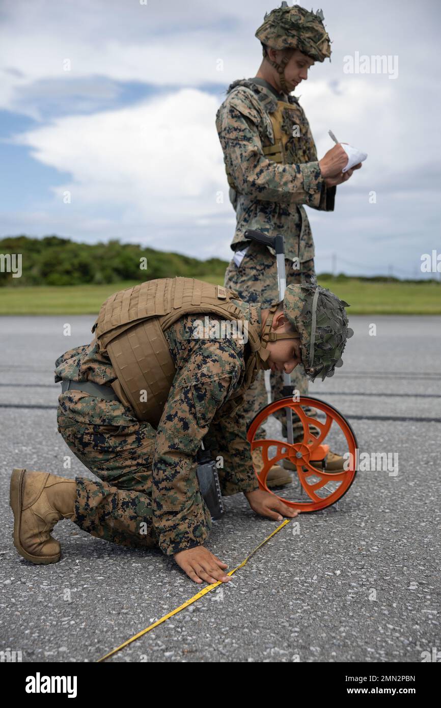 U.S. Marine Corps Lance CPL. Daniel Gollas, Kampfingenieur bei Marine Wing Support Squadron (MWSS) 172, misst den Abstand zwischen beschädigten Bereichen der Startbahn während einer grundlegenden Trainingsübung zur Erholung nach einem Angriff (BRAAT) auf der Marine Corps Air Station Futenma, 25. September 2022. MWSS-172 führte einen BRAAT durch, um die Bereitschaft zu wahren, indem er die Fähigkeit demonstrierte, einen Flugplatz nach einem simulierten Angriff schnell wieder einsatzbereit zu machen. Stockfoto