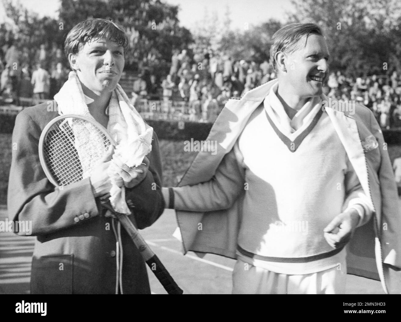 German tennis player Baron Gottfried von Cramm, right, is seen with Denmark's Torben Ulrich whom he defeated 6-4 6-2 6-4 in the final match of the second round of the Davis Cup on May 20, 1951 in Berlin, Germany. West Germany won the tie by 4 matches to 1. (AP Photo/Hans von Nolde) Stockfoto