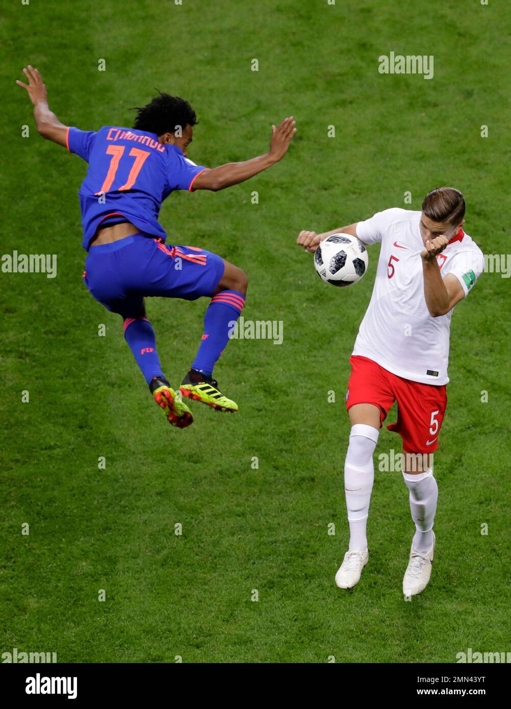 Colombia's Juan Cuadrado, left, and Poland's Jan Bednarek battle for the ball during the group H match between Poland and Colombia at the 2018 soccer World Cup at the Kazan Arena in Kazan, Russia, Sunday, June 24, 2018. (AP Photo/Sergei Grits) Stockfoto