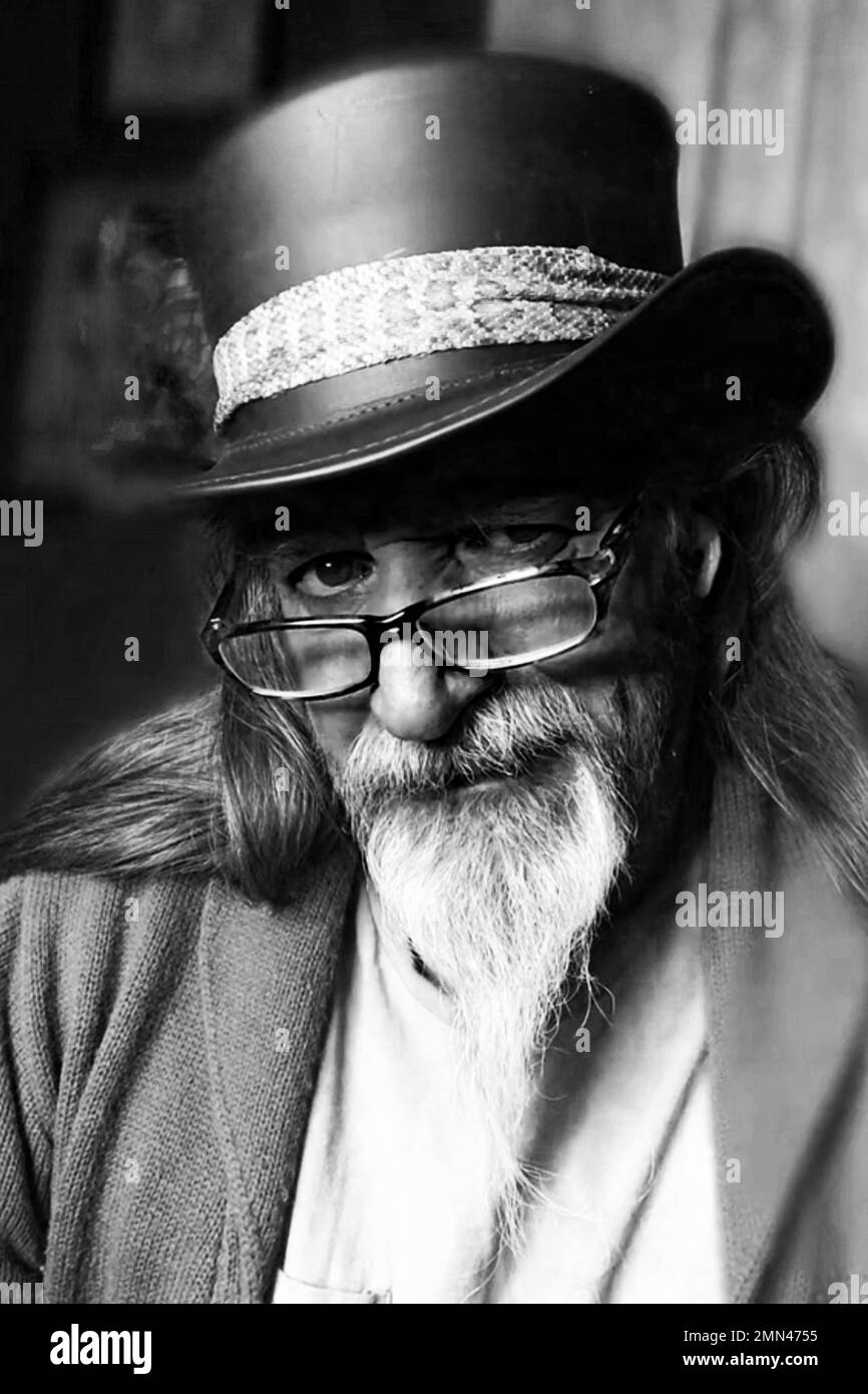 Ältere Person mit langem Bart und altem Hut posiert für ein Porträt Stockfoto