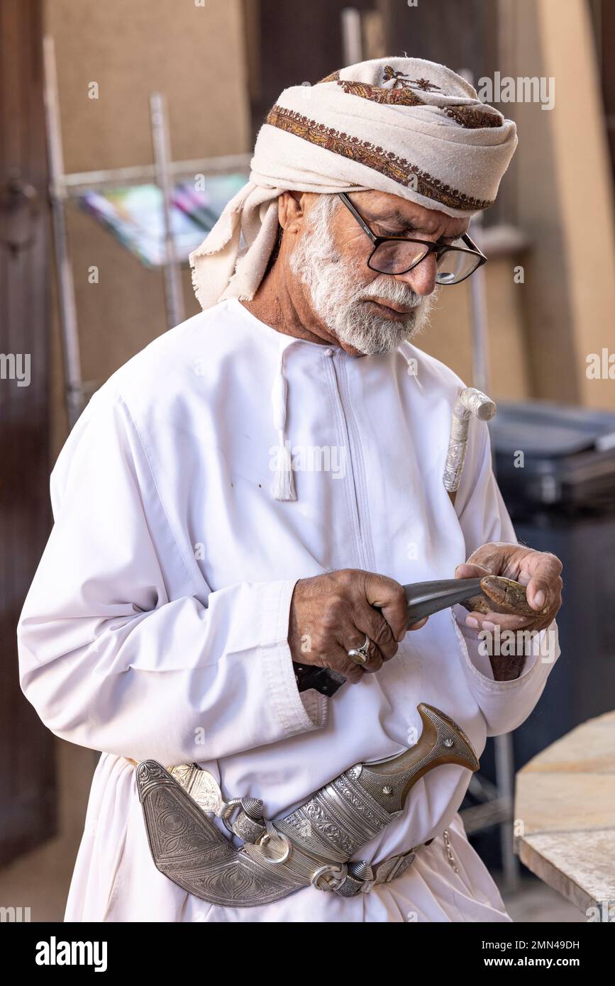 Nizwa, Oman, 2. Dezember 2022: omanischer Mann in traditioneller Ausrüstung auf dem Waffenmarkt Stockfoto