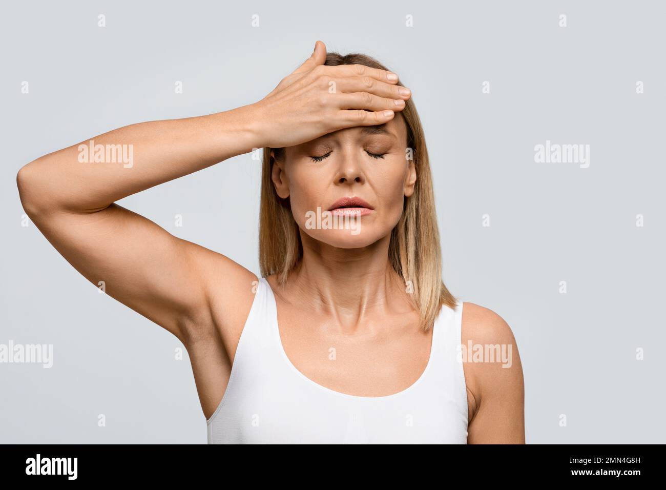 Frau mittleren Alters, die unter starken Kopfschmerzen leidet Stockfoto