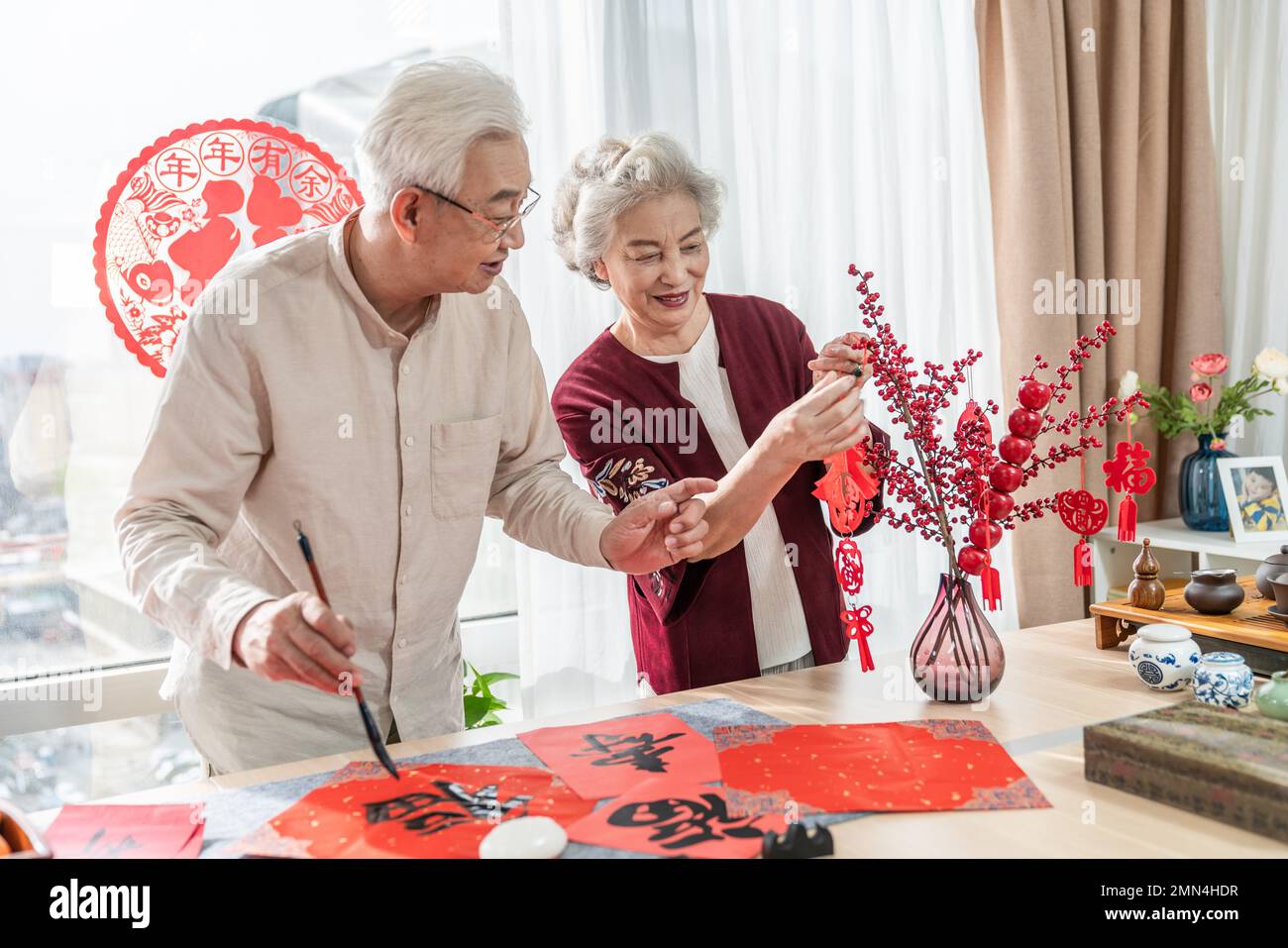 Glücklicher alter Mann und Frau zu Hause, um Kalligraphie zu schreiben Stockfoto
