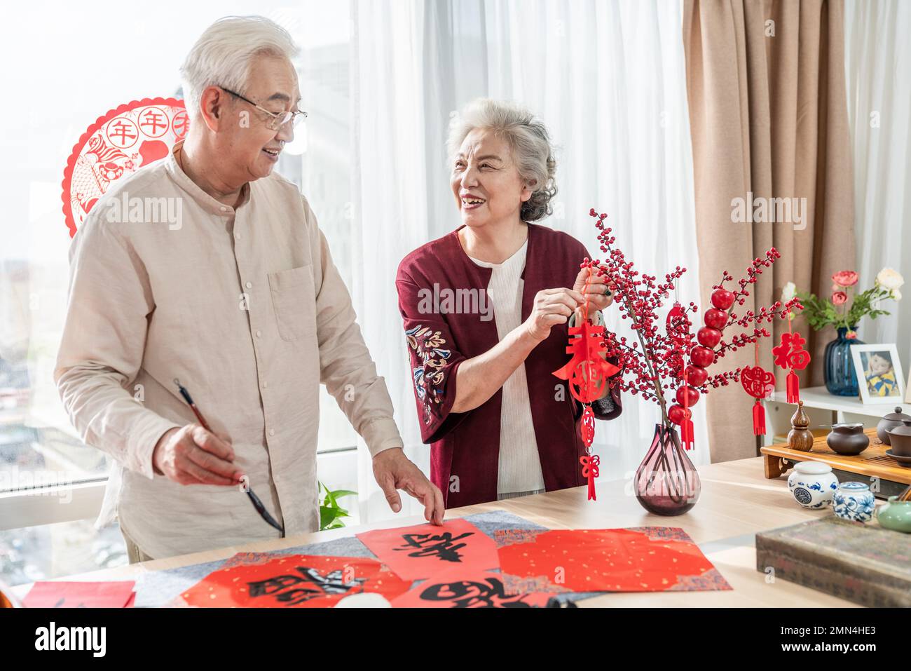 Glücklicher alter Mann und Frau zu Hause, um Kalligraphie zu schreiben Stockfoto
