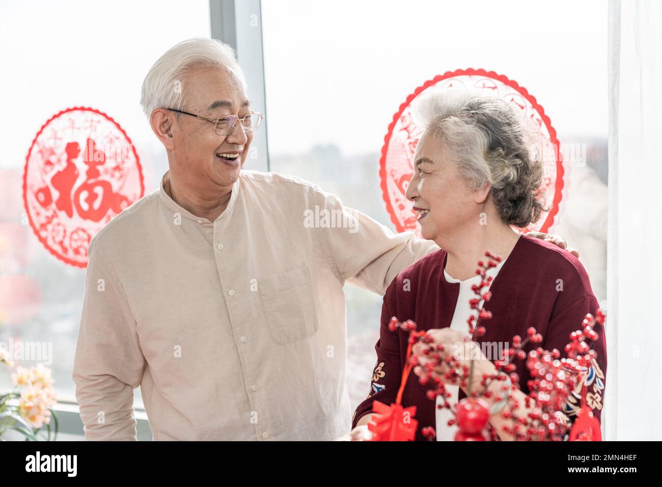Glückliches altes Paar hängt Laternen zu Hause auf Stockfoto