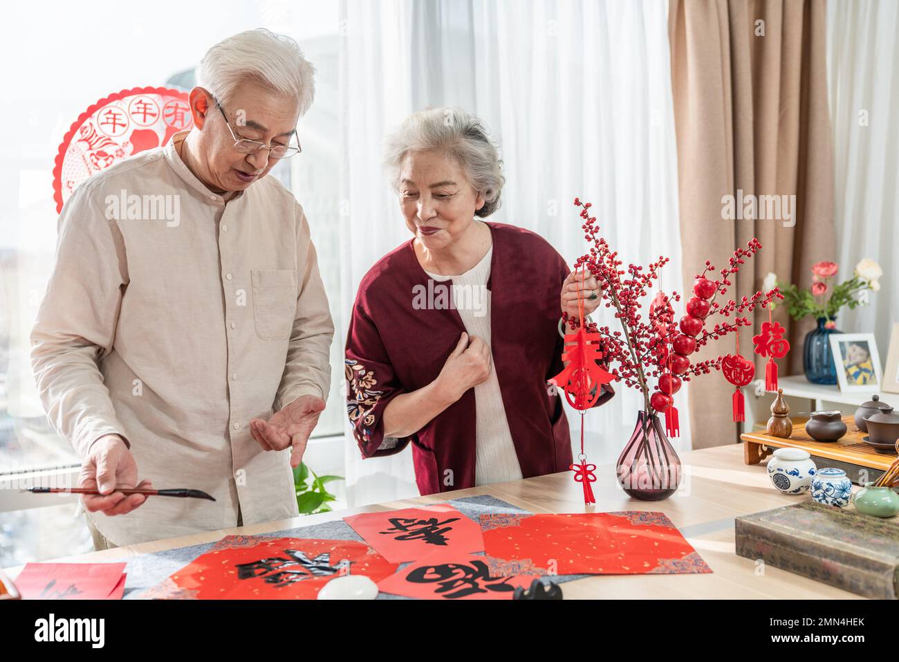 Glücklicher alter Mann und Frau zu Hause, um Kalligraphie zu schreiben Stockfoto