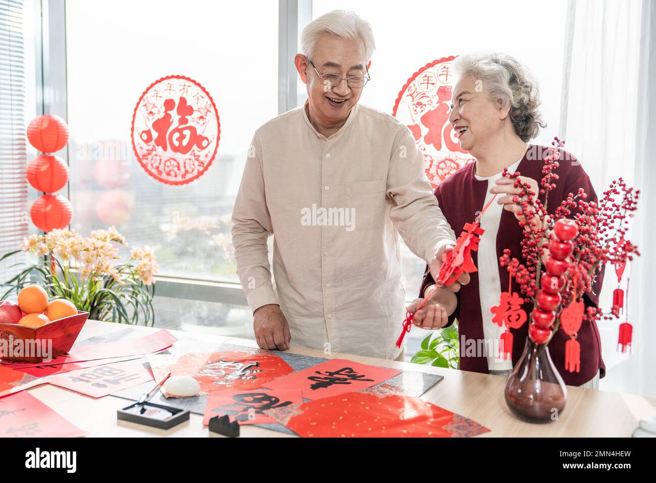 Glücklicher alter Mann und Frau zu Hause, um Kalligraphie zu schreiben Stockfoto