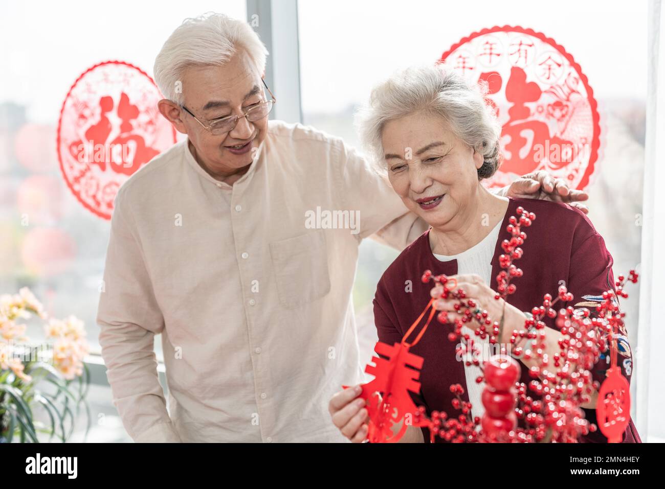 Glückliches altes Paar hängt Laternen zu Hause auf Stockfoto