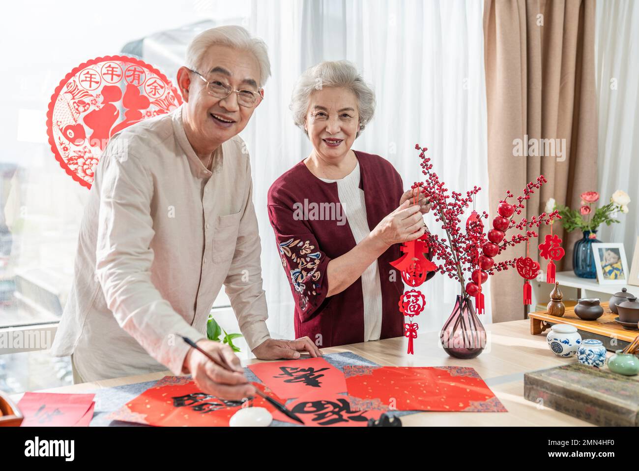 Glücklicher alter Mann und Frau zu Hause, um Kalligraphie zu schreiben Stockfoto