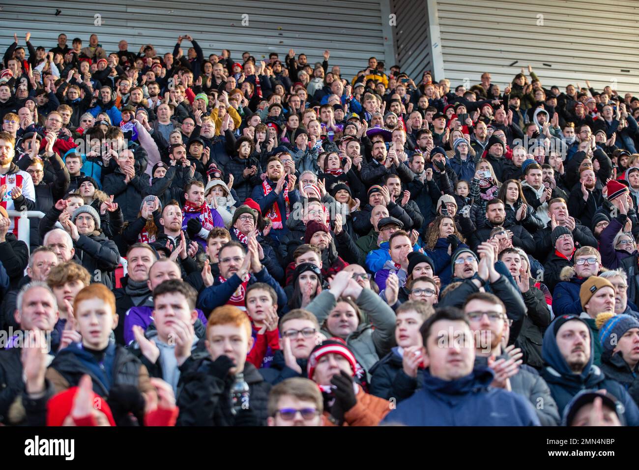 Fußballfans und Fans applaudieren ihrem Team während des Spiels vom Stand aus und jubeln es an Stockfoto