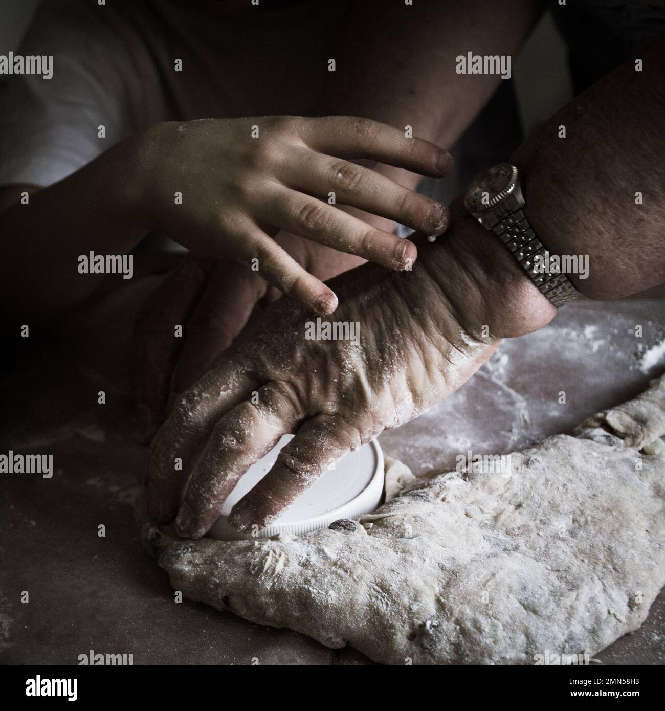 Großmutter und Enkelkind backen Brot und kneten Teig zusammen Stockfoto