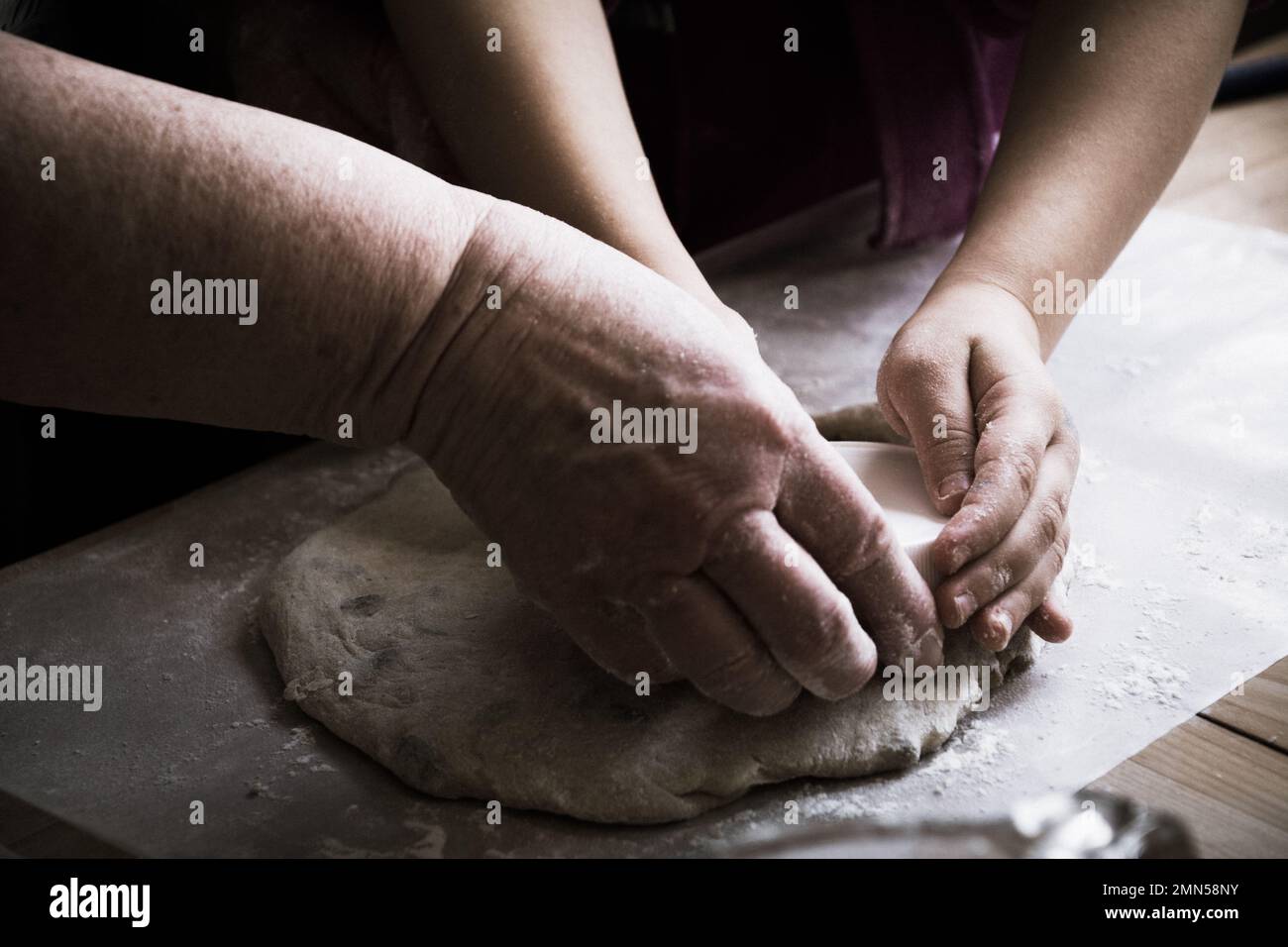 Großmutter und Enkelkind backen Brot und kneten Teig zusammen Stockfoto
