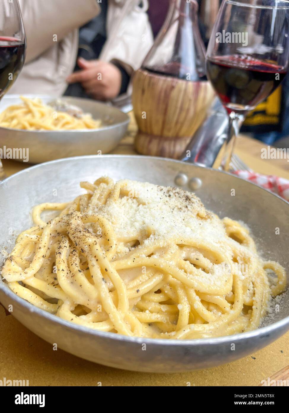 italienisches Essen, leckere handgemachte Pasta mit Käse auf dem Tisch. Typische und traditionelle italienische Spaghetti und lokale Rotweine auf dem Tisch in Rom, IT Stockfoto