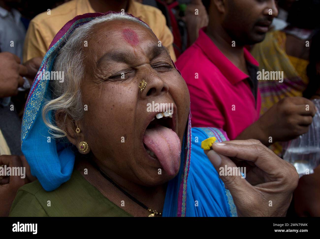 An Indian asthma patient opens her mouth wide to be administered a