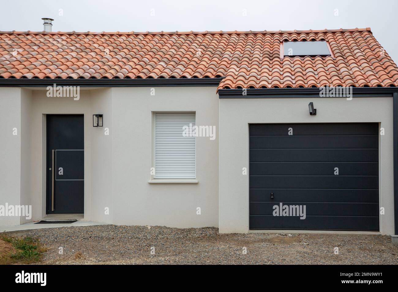 Moderne Fassade mit moderner grauer Garagentür Stockfoto