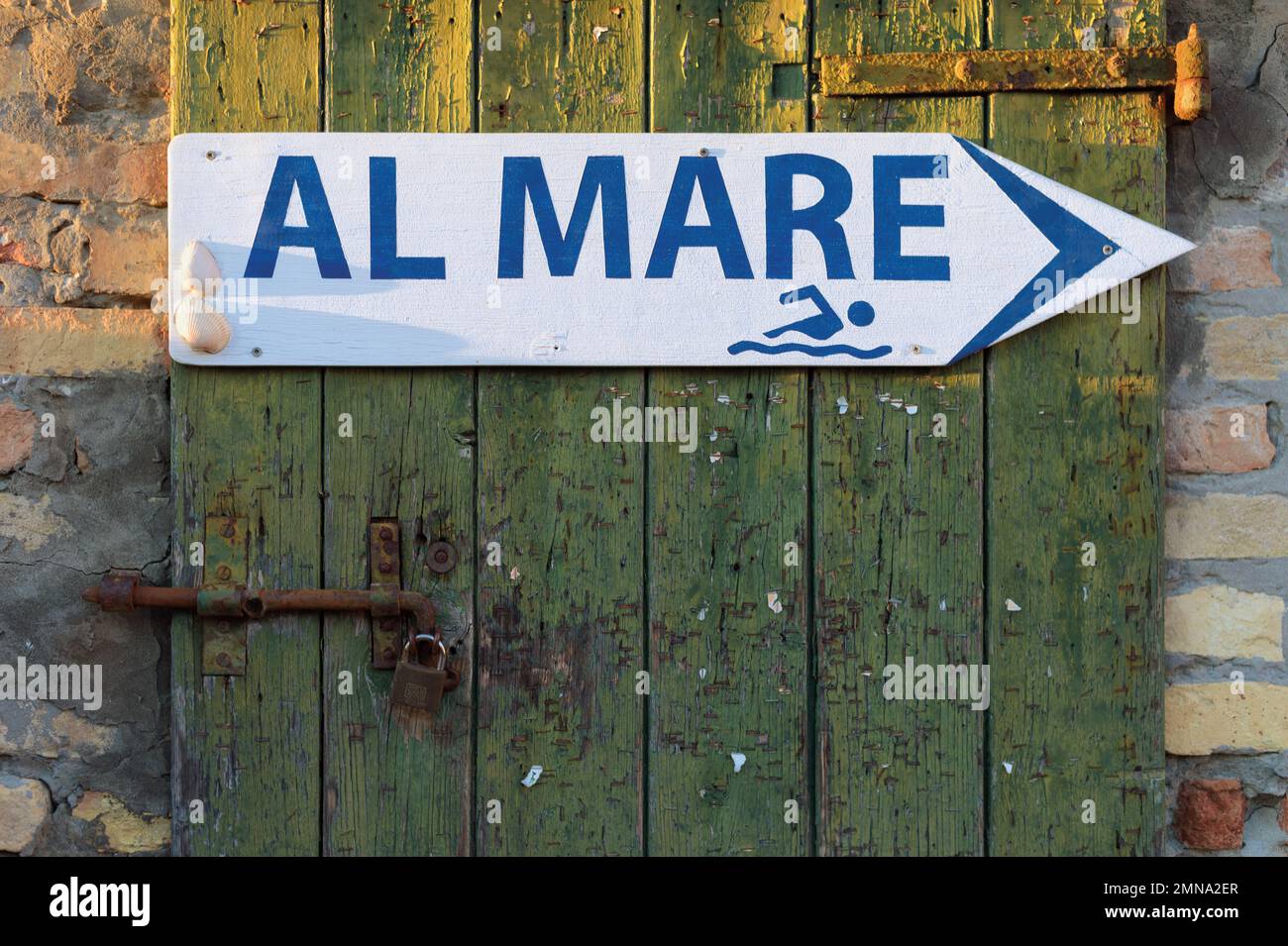 Altes Holztür- und Richtungspfeil-Schild nach rechts mit den italienischen Wörtern Al Mare für das Meer, mit grafischer Form eines Mannes Stockfoto