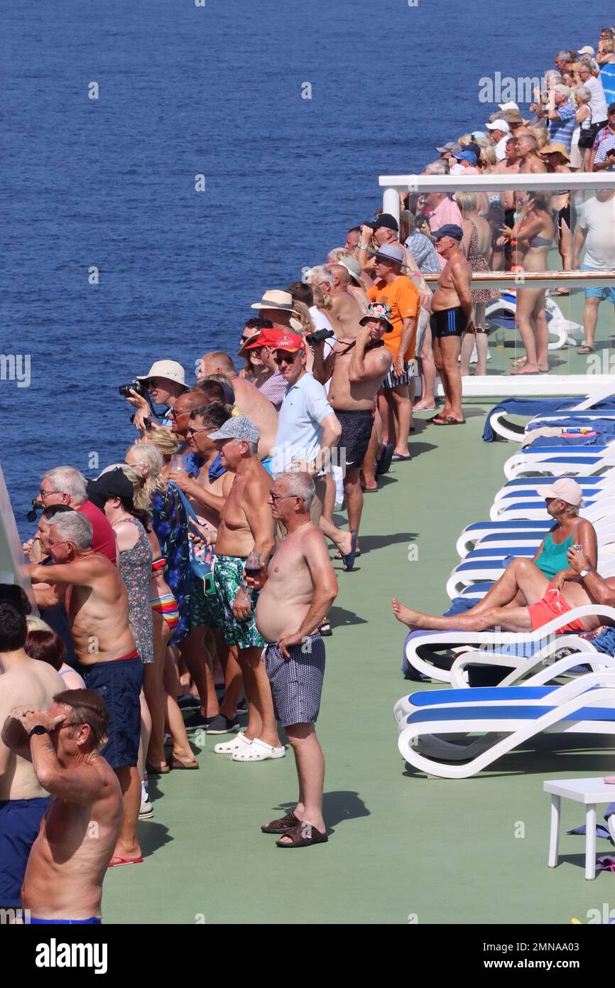 Kreuzfahrtpassagiere an Bord des Kreuzfahrtschiffs Aurora beobachten ein überladenes Migrantenschiff, das ohne Strom im Mittelmeer 100 Meilen von Land entfernt treibt. Stockfoto