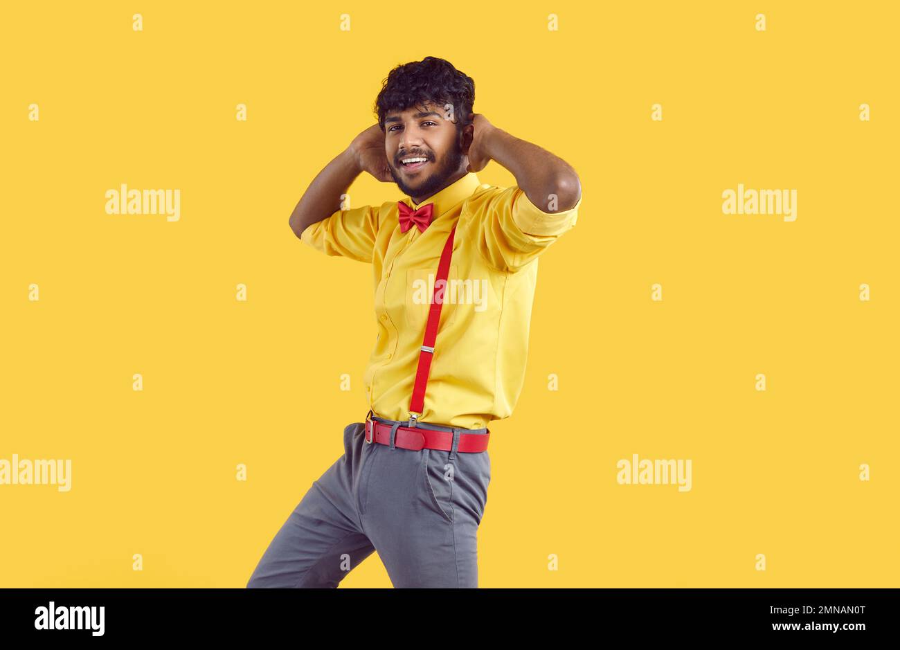 Ein lustiger, positiver araber, der Spaß hat, glücklich ist und isoliert auf orangefarbenem Hintergrund tanzt. Stockfoto