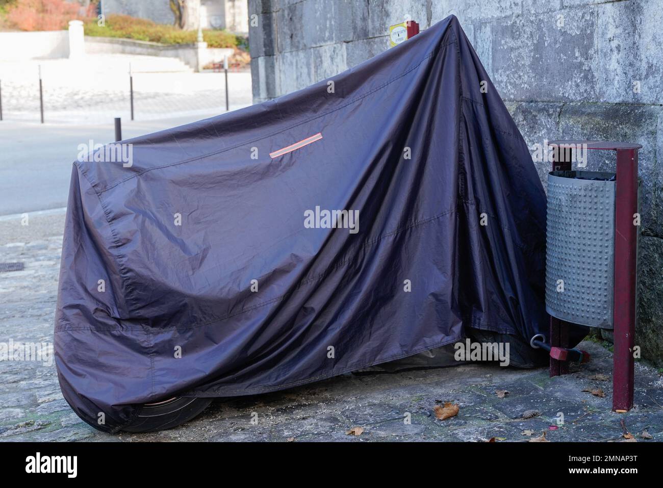 Motorrad auf der Straße geschützt durch eine Schutzhülle Motorrad Planenjacke Stockfoto