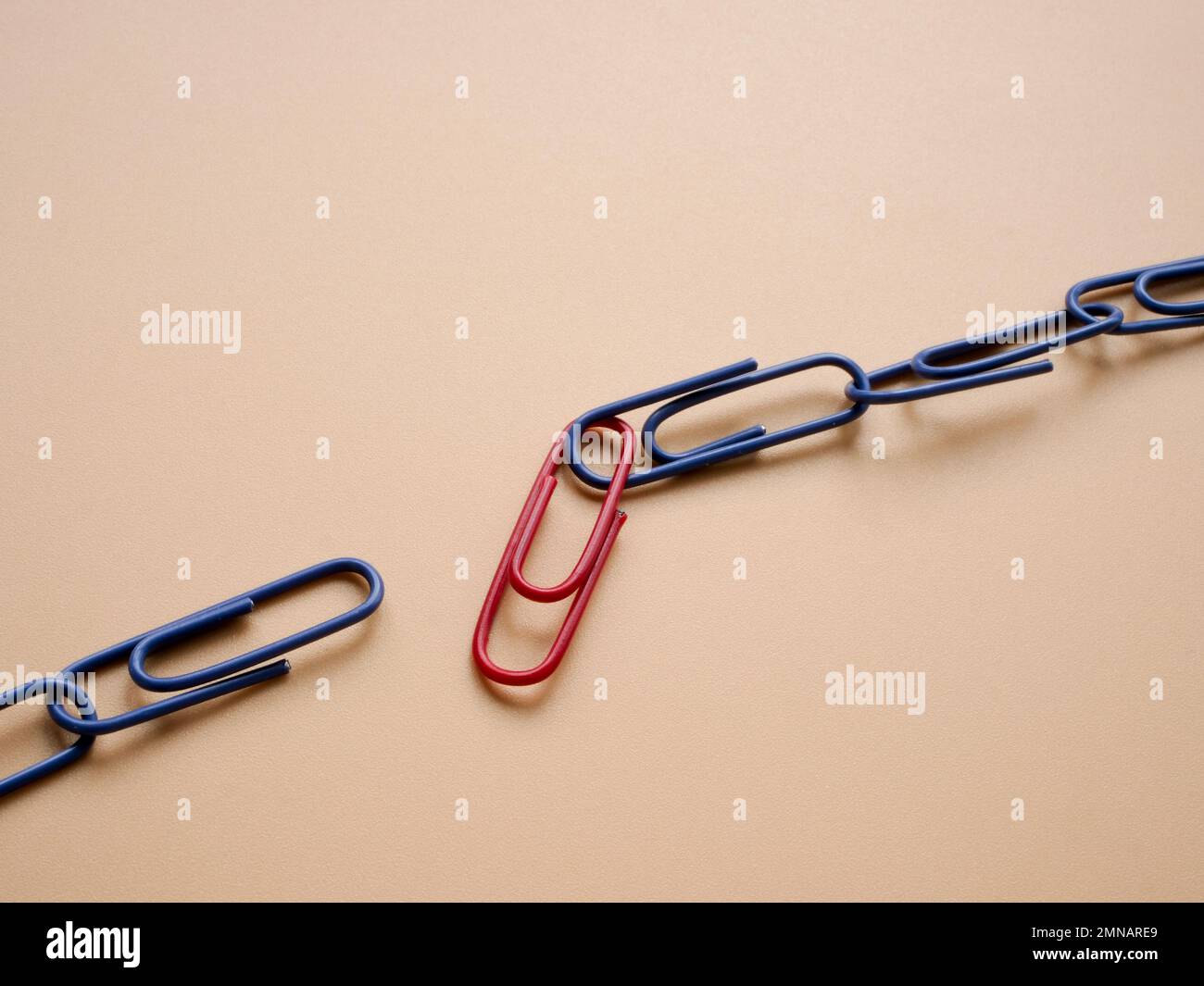 Die Kette der Heftklammern ist gebrochen. Schwaches Gliederkonzept. Stockfoto