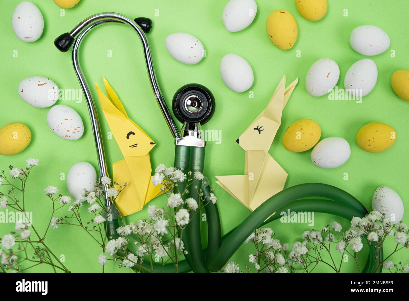 Fröhliche und gesunde Ostern - medizinische Karte mit Stethoskop, Osterhasen und Eiern Stockfoto