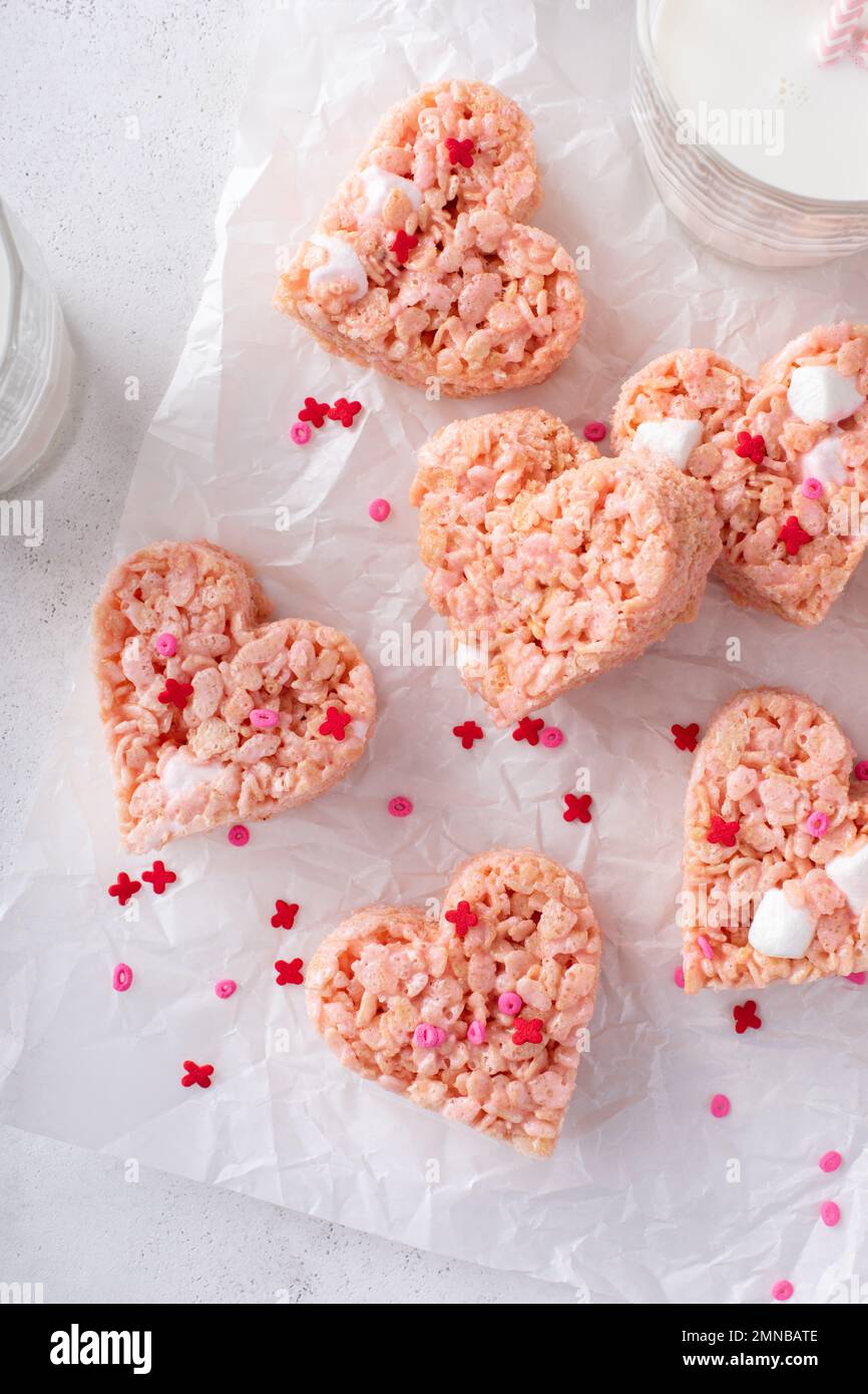 Herzförmige rosa Reiskrispie-Leckereien zum Valentinstag, romantische Snackidee Stockfoto