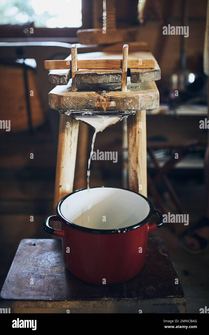 Käseherstellung. Herstellung von Hüttenkäse mit Käsepresse und traditioneller alter Technik. Alte rustikale Küche Stockfoto