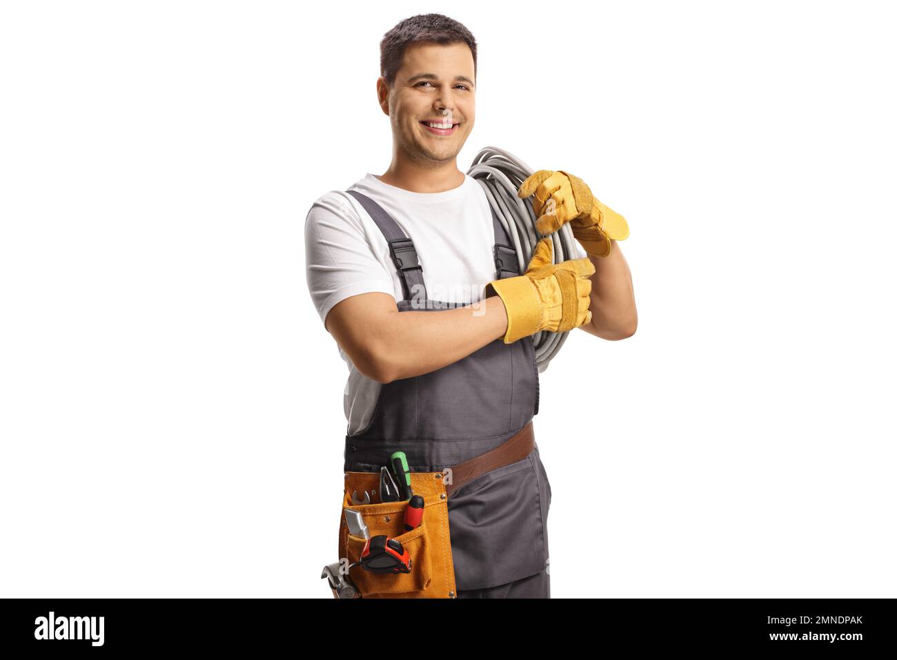 Junger Elektriker, der Kabel an der Schulter trägt, isoliert auf weißem Hintergrund Stockfoto