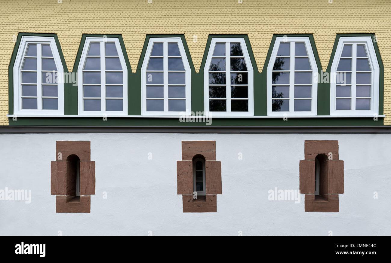 Reihe von Trapezfenstern über drei sehr schmalen Fenstern mit Steinrahmen Stockfoto