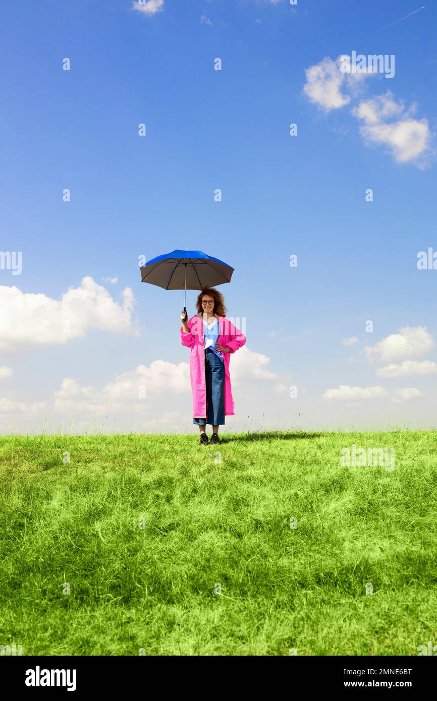 Junge Frau mit einem lächelnden Regenschirm Stockfoto