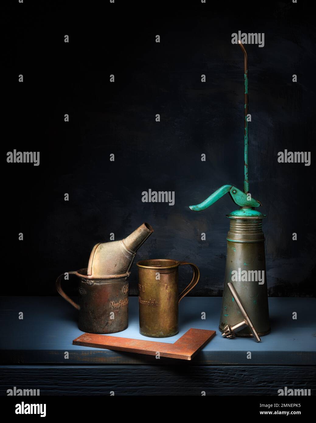 Stillleben mit alter Ölkanne, Metallwinkel und Bohrfutterschlüssel, Studioaufnahme, dunkler Hintergrund Stockfoto