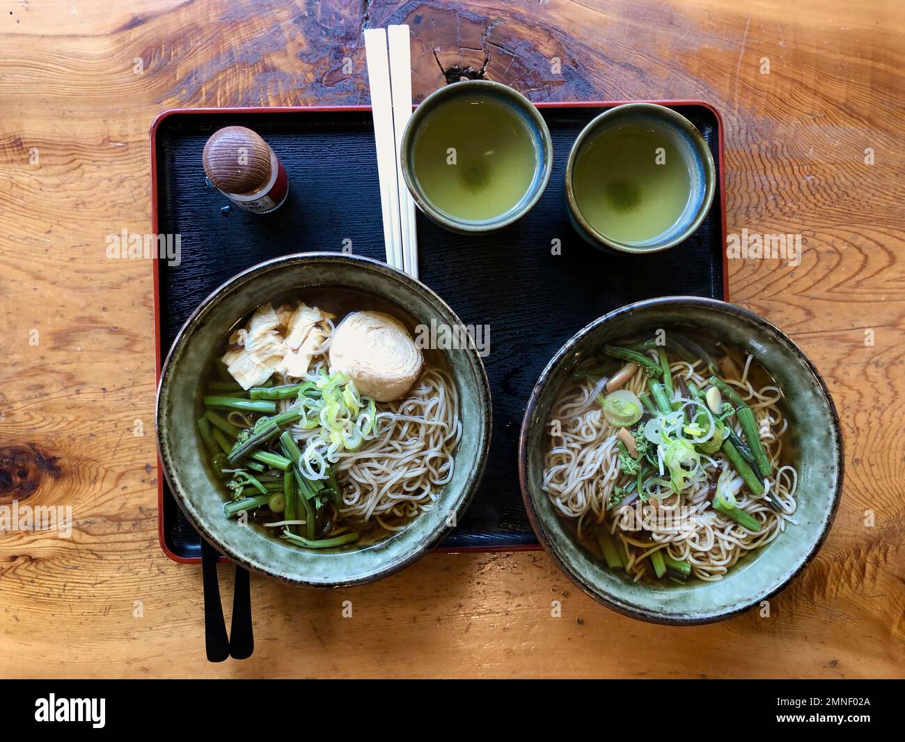 Tablett mit zwei Portionen traditioneller japanischer Nudelsuppe und grünem Tee, Ramen mit Wildgemüse, Nikko, Japan Stockfoto