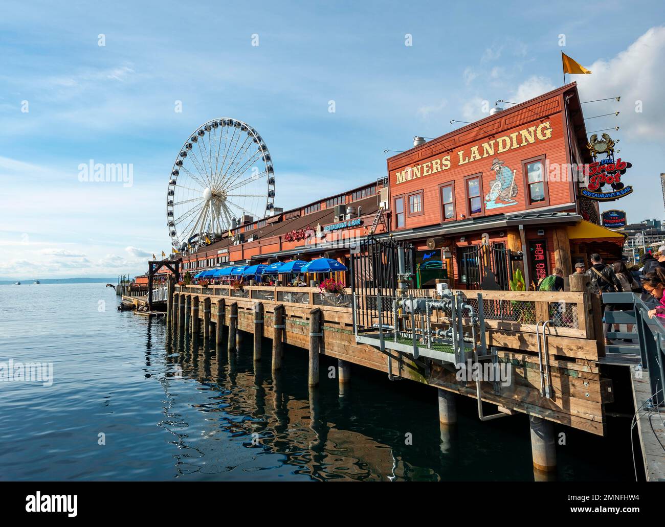 Waterfront, Miners Landing am Pier 57, hinter dem Riesenrad The Seattle Great Wheel, Seattle, Washington, USA Stockfoto