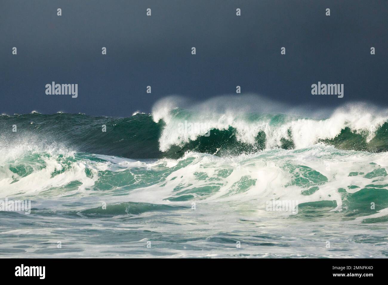 Große Wellen auf dem offenen Meer und dramatisches Licht vor der Nordküste Irlands, Fintra Beach in der Grafschaft Donegal Stockfoto