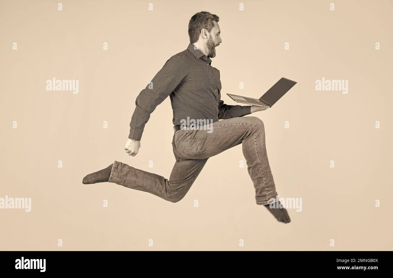 Überrascht energischer Mann läuft während der Arbeit online auf Laptop beeilen Sie sich zum Einkaufen, Einkaufen. Stockfoto